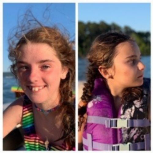 Two girls enjoying a boat ride, smiling and posing for the camera in a scenic outdoor setting.