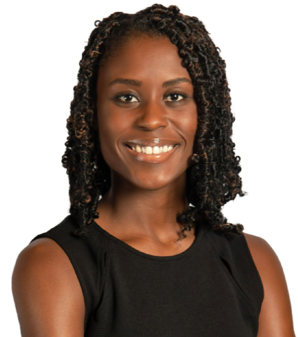 A woman with shoulder-length curly hair wearing a sleeveless black top smiles confidently against a plain white background.